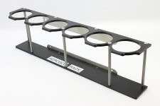 This rack holds 6 aerosol spray cans and can be attached to a work bench or trailer door.
